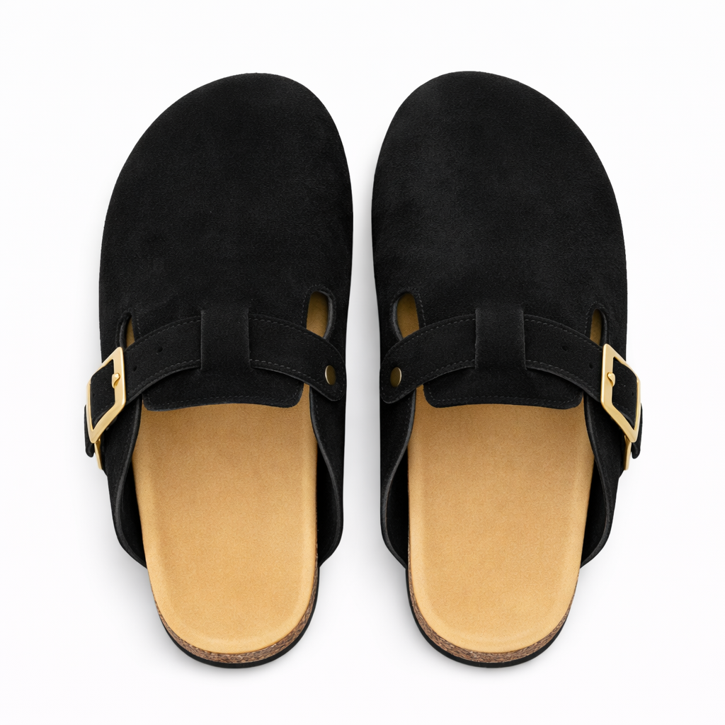 Pair of black suede clogs with gold buckles on a white background